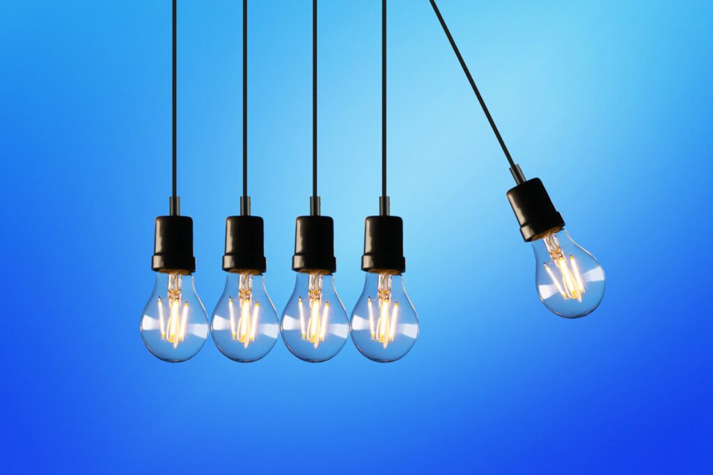 5 lightbulbs as Newtons Cradle knocking into each other to show the power of creativity